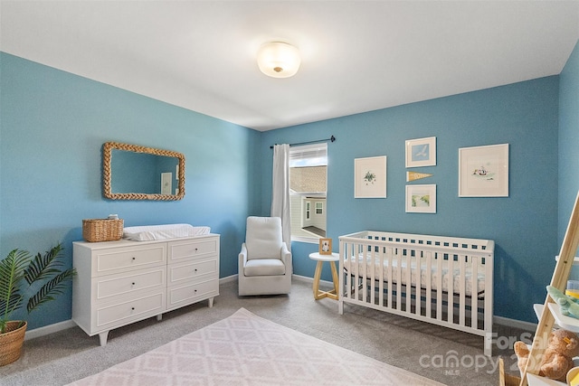 carpeted bedroom featuring a crib