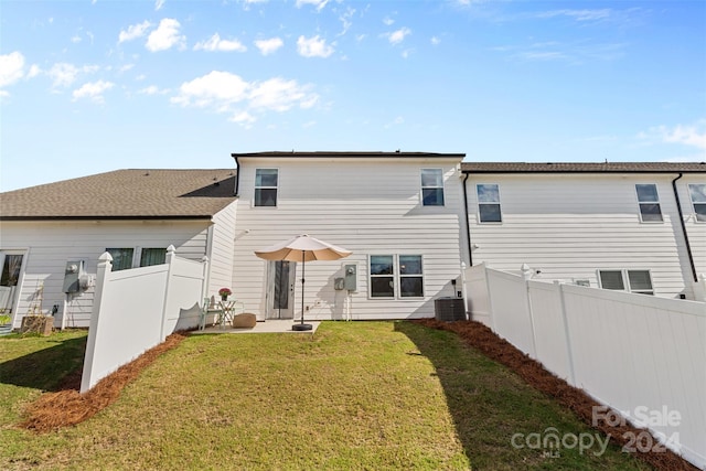 rear view of house featuring a yard, a patio area, and central AC