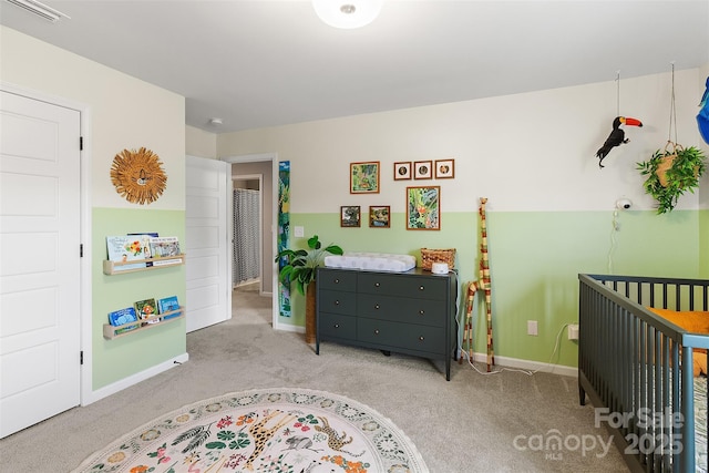 bedroom with a crib and light colored carpet