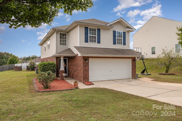 view of property with a garage and a front lawn