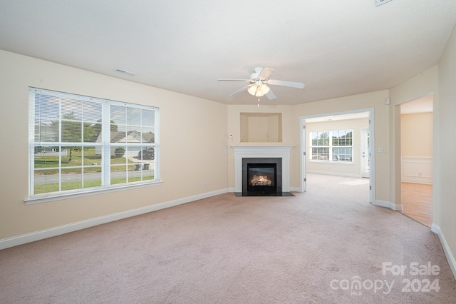 unfurnished living room with light carpet and ceiling fan