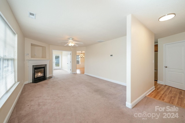 unfurnished living room featuring ceiling fan and light colored carpet