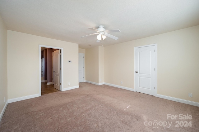 interior space with baseboards, a ceiling fan, and carpet