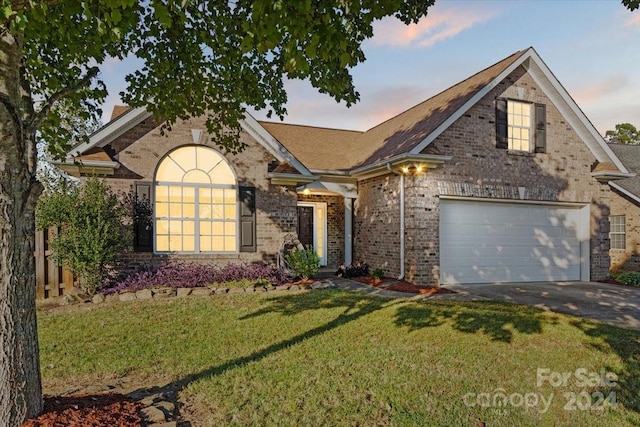 view of front of home with a garage and a lawn