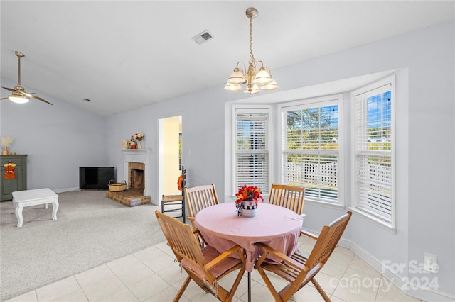 carpeted dining area featuring ceiling fan with notable chandelier