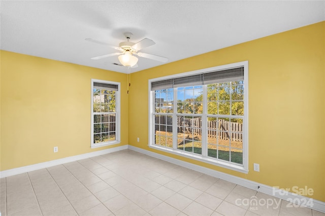 spare room featuring ceiling fan and light tile patterned flooring