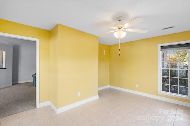 empty room with light tile patterned floors and ceiling fan