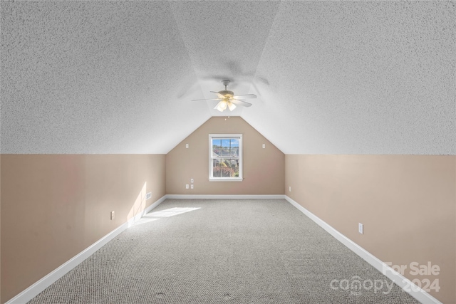 additional living space featuring carpet floors, ceiling fan, a textured ceiling, and vaulted ceiling