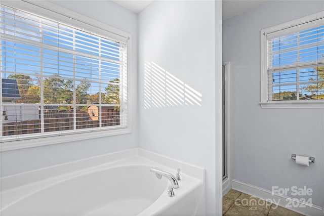 bathroom with shower with separate bathtub, plenty of natural light, and tile patterned flooring