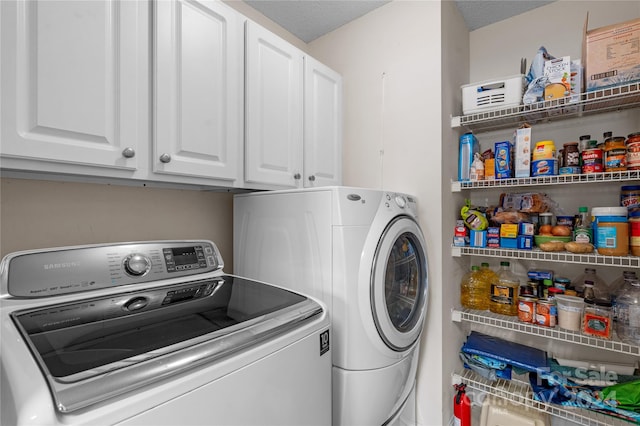 laundry room featuring independent washer and dryer, a textured ceiling, and cabinets