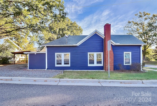 view of side of home featuring a lawn and a carport