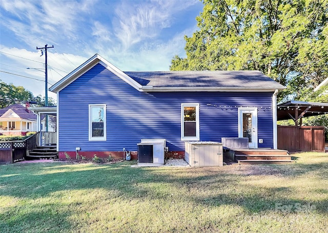 back of property featuring a lawn and cooling unit