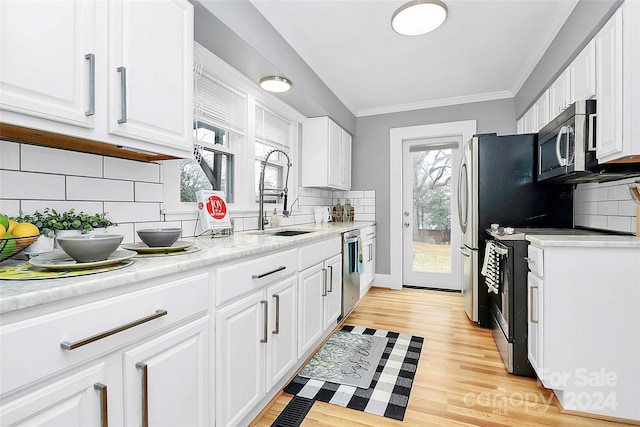 kitchen with sink, white cabinets, stainless steel appliances, and light wood-type flooring