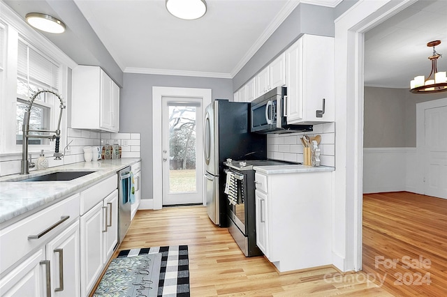 kitchen featuring sink, stainless steel appliances, tasteful backsplash, white cabinets, and light wood-type flooring