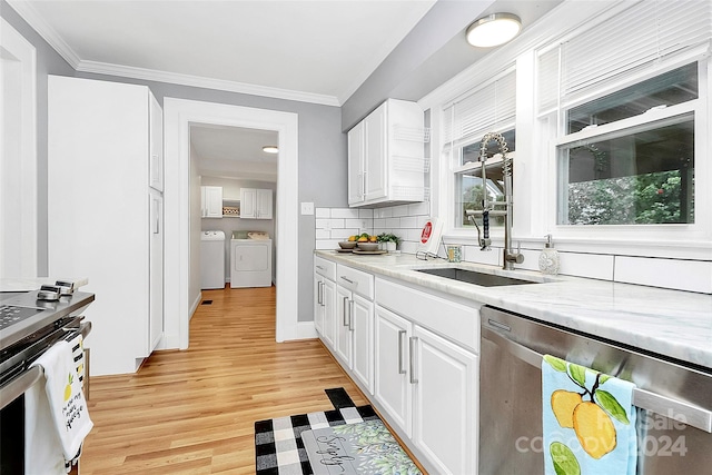 kitchen with ornamental molding, washer and clothes dryer, dishwasher, light hardwood / wood-style floors, and white cabinetry