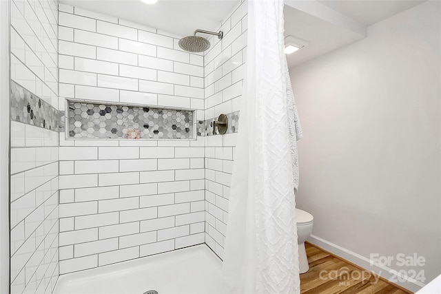 bathroom with curtained shower, wood-type flooring, and toilet