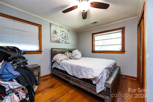 bedroom with ceiling fan, a closet, dark hardwood / wood-style floors, and ornamental molding