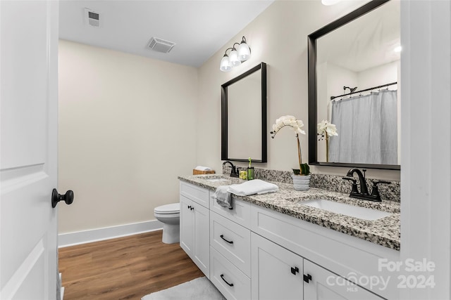 bathroom featuring hardwood / wood-style floors, toilet, vanity, and a shower with curtain