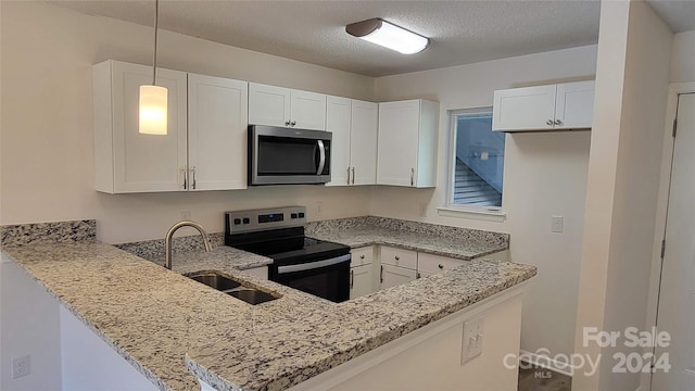 kitchen featuring pendant lighting, white cabinets, and appliances with stainless steel finishes