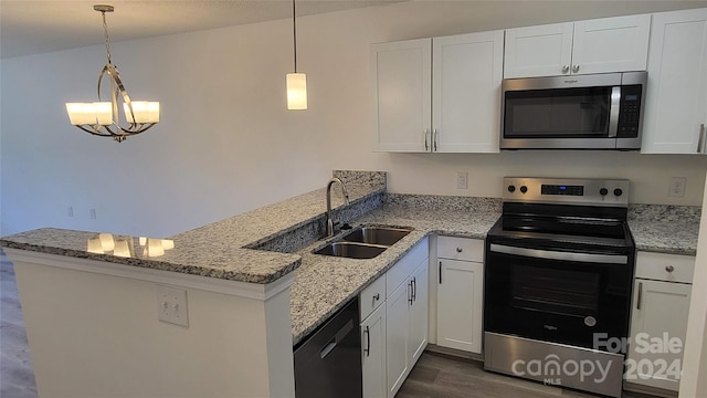 kitchen with stainless steel appliances, hanging light fixtures, sink, and white cabinetry