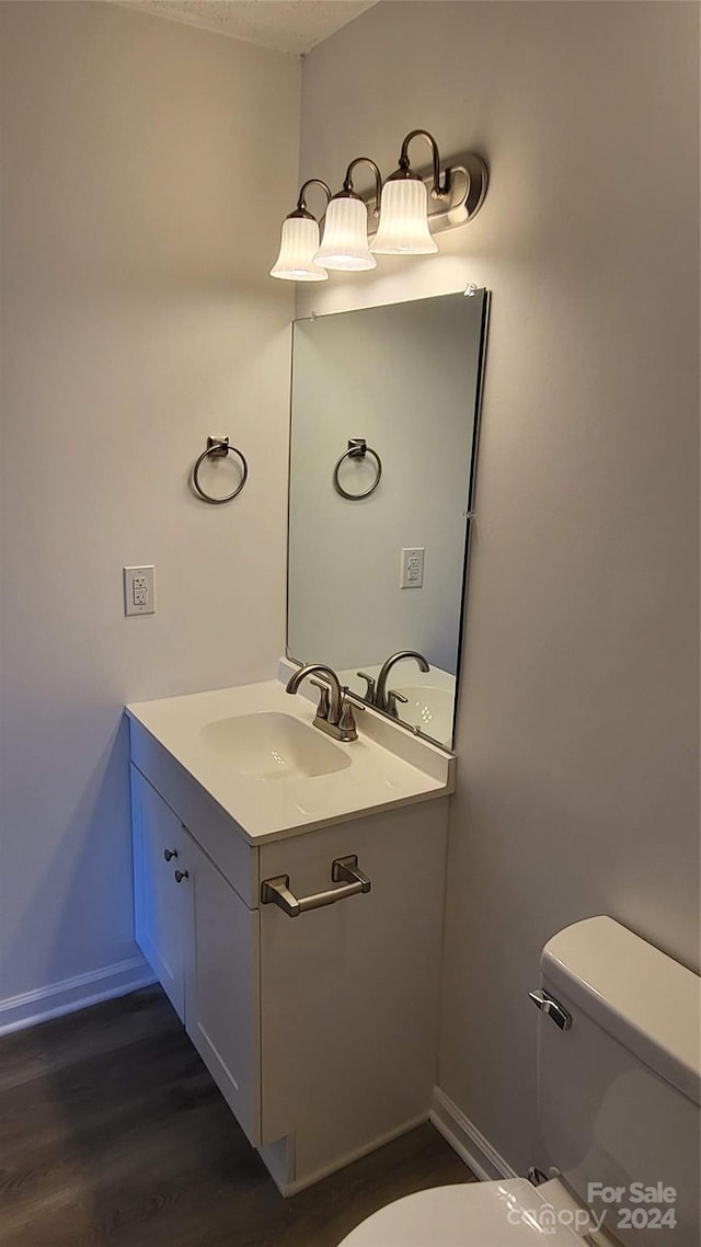 bathroom with vanity, hardwood / wood-style floors, and toilet