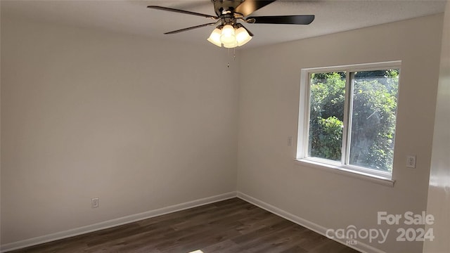 unfurnished room featuring ceiling fan, dark wood-type flooring, and a healthy amount of sunlight