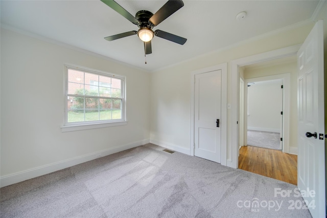 unfurnished bedroom with ornamental molding, ceiling fan, and carpet flooring