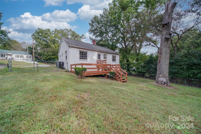 rear view of house featuring a deck and a lawn