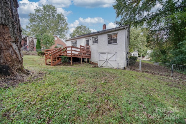 rear view of property with a yard and a deck