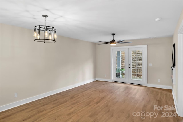 spare room with wood-type flooring, ceiling fan with notable chandelier, and french doors