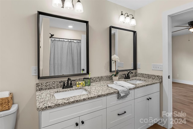 bathroom featuring ceiling fan, hardwood / wood-style floors, vanity, and toilet