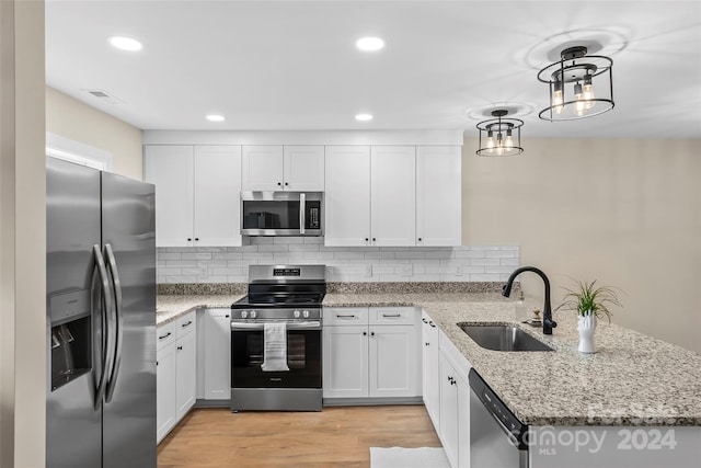 kitchen with appliances with stainless steel finishes, sink, and white cabinets