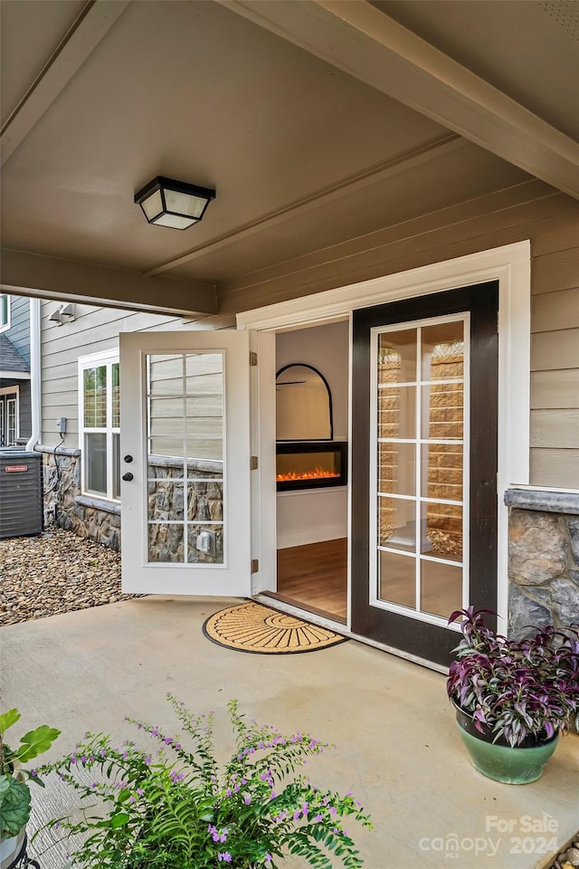 doorway to property with central AC and a patio area