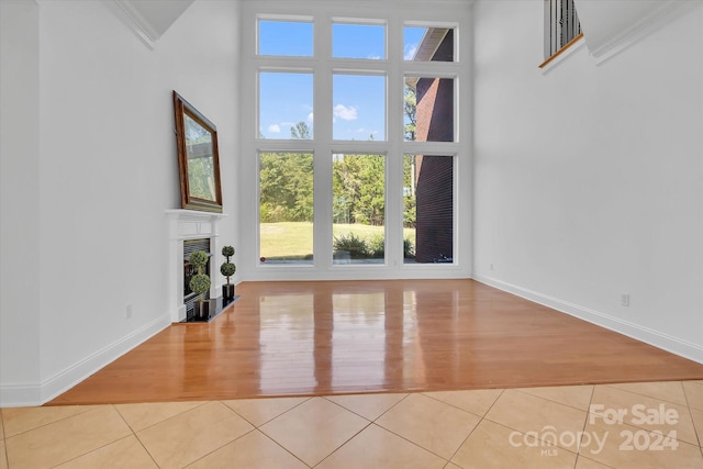 unfurnished living room with light tile patterned flooring and a wealth of natural light