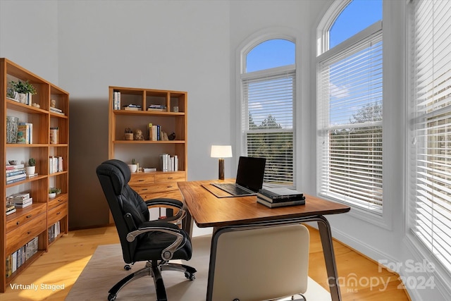 home office with light wood-type flooring and plenty of natural light