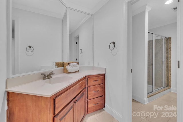 bathroom featuring vanity, a shower with shower door, tile patterned flooring, and crown molding