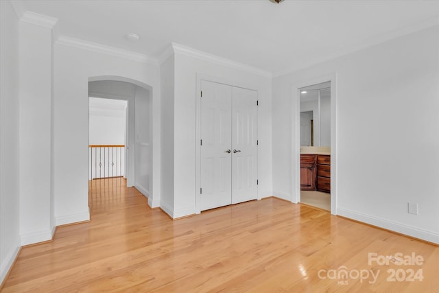 unfurnished room with ornamental molding and light wood-type flooring