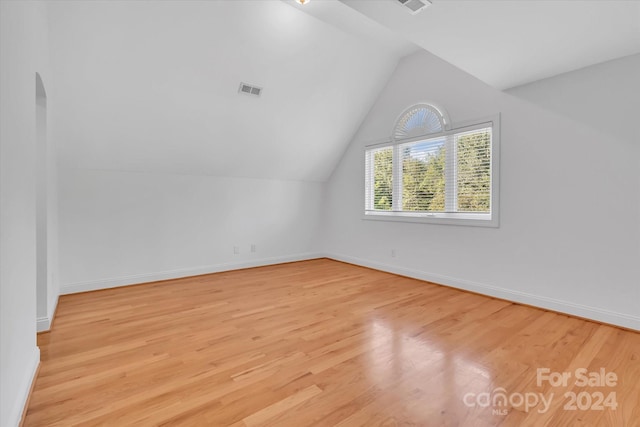 bonus room featuring light wood-type flooring and lofted ceiling