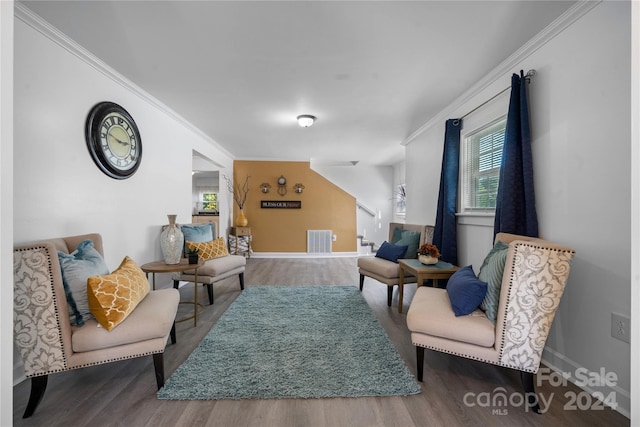 sitting room with crown molding and wood-type flooring