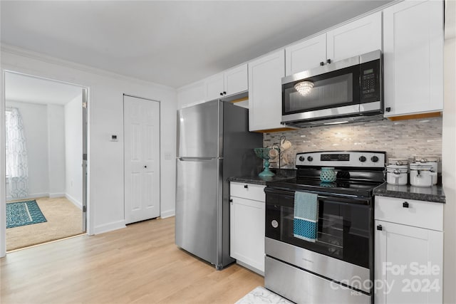 kitchen featuring light hardwood / wood-style floors, decorative backsplash, white cabinetry, and stainless steel appliances