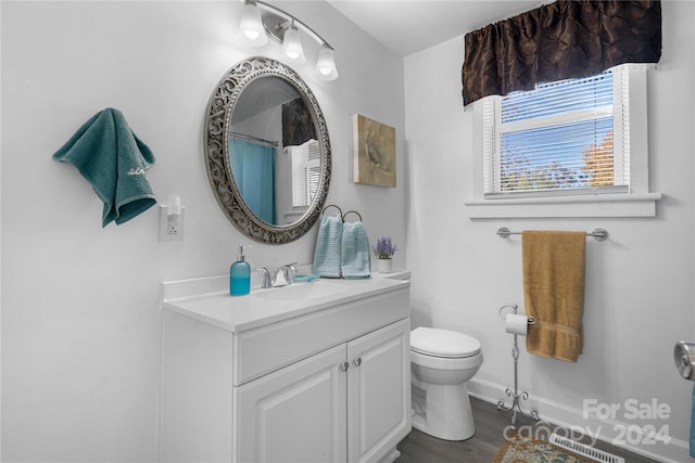 bathroom featuring toilet, hardwood / wood-style flooring, and vanity