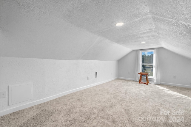 bonus room featuring a textured ceiling, carpet, and vaulted ceiling