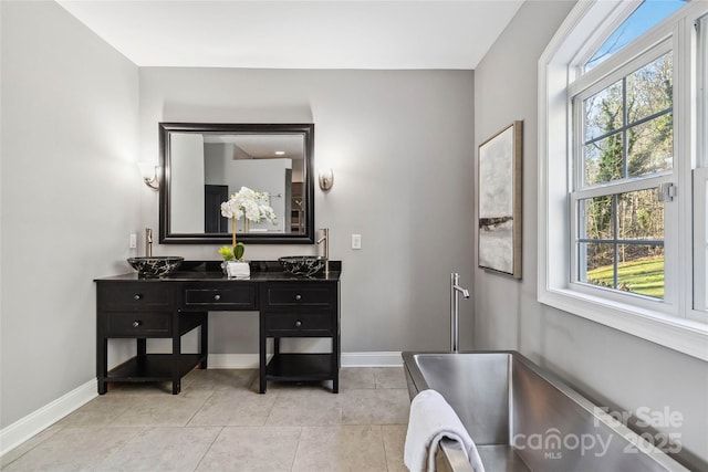 bathroom featuring vanity, tile patterned flooring, and a tub