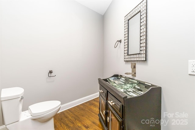 bathroom featuring vanity, toilet, and hardwood / wood-style floors