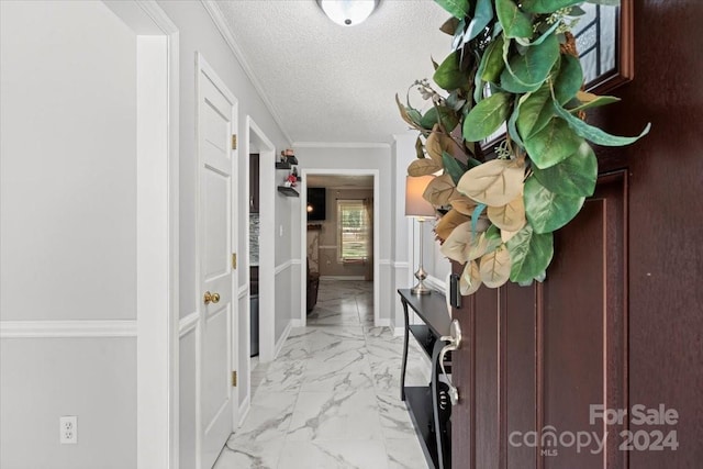 corridor with crown molding and a textured ceiling