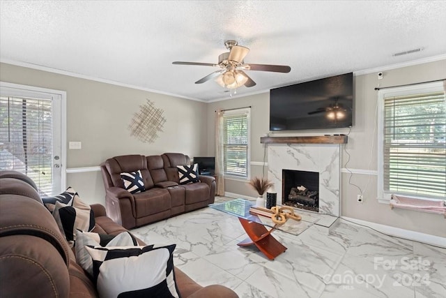 living room with a premium fireplace, a healthy amount of sunlight, and crown molding