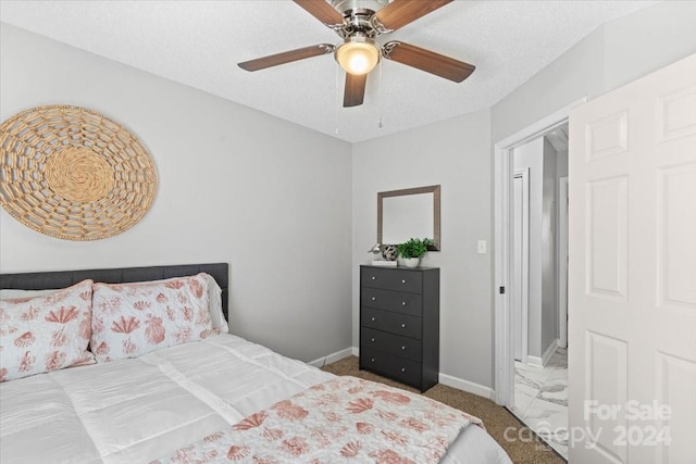 bedroom with a textured ceiling, ceiling fan, and carpet flooring