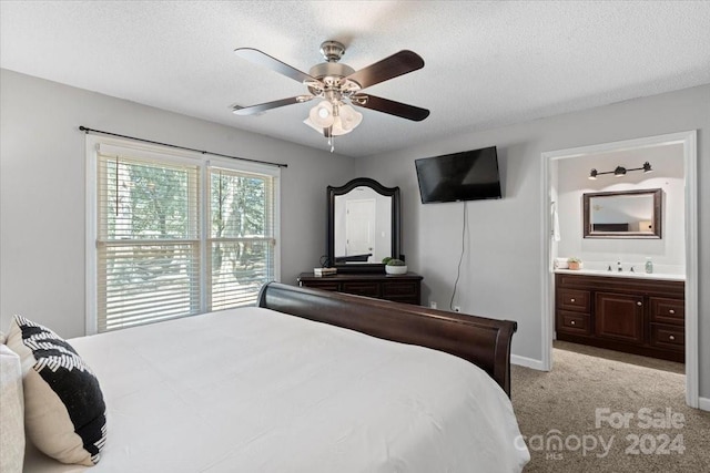 carpeted bedroom featuring ensuite bath, ceiling fan, and a textured ceiling