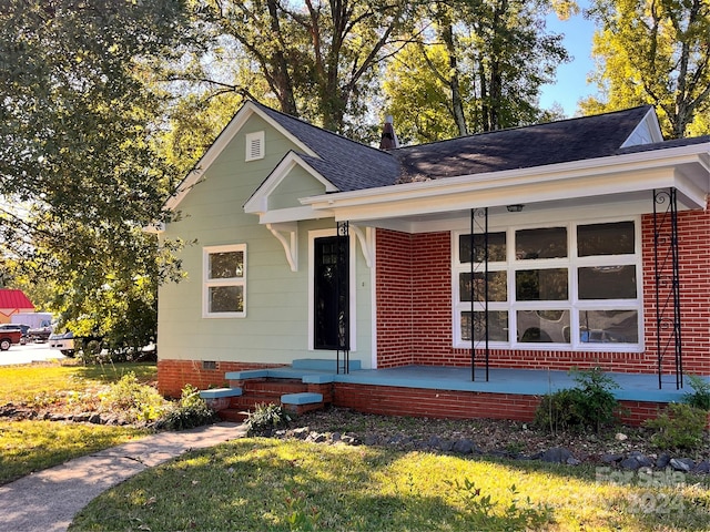 view of front of home with a front yard and covered porch