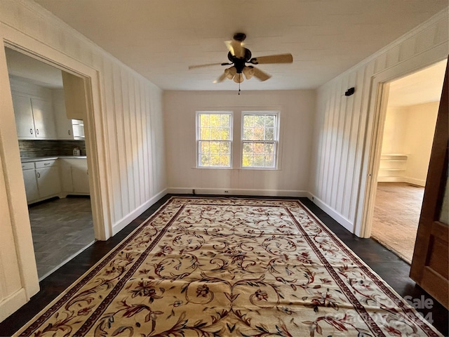 unfurnished room featuring ornamental molding, ceiling fan, and dark wood-type flooring